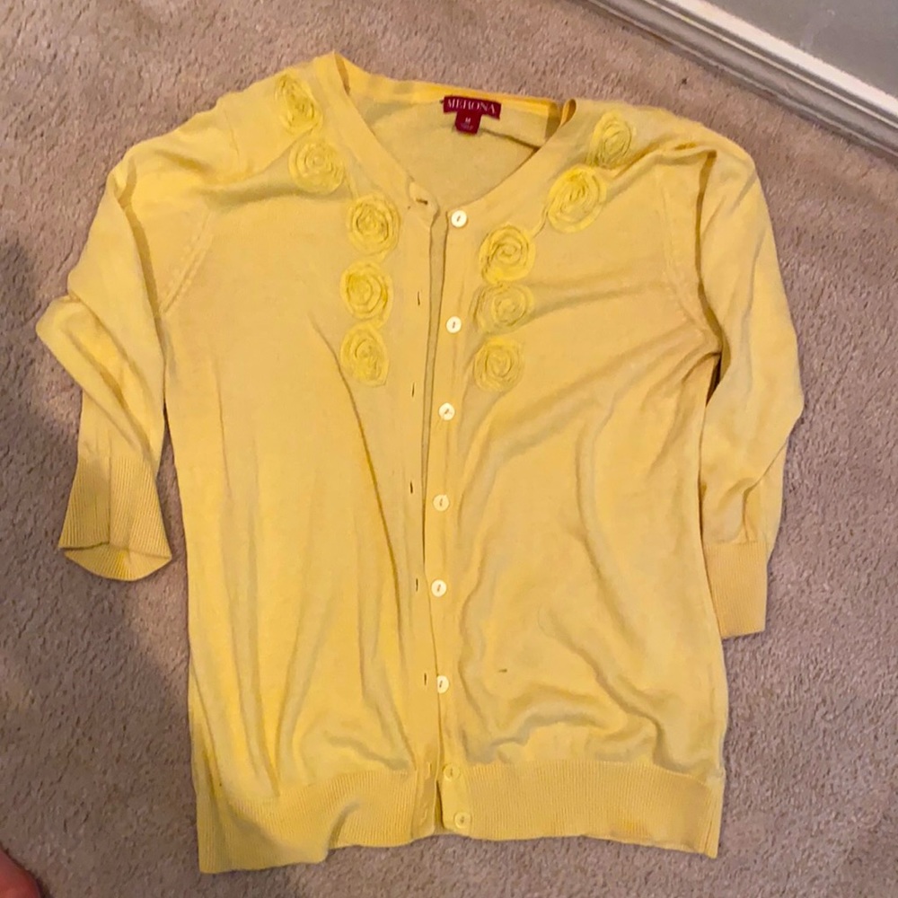Then yellow sweater with rosettes
